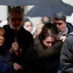 People hold a vigil to honour victims of Prague shooting