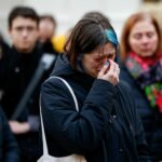 People hold a vigil to honour victims of Prague shooting