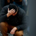 People hold a vigil to honour victims of Prague shooting