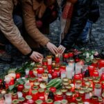People hold a vigil to honour victims of Prague shooting
