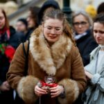 People hold a vigil to honour victims of Prague shooting