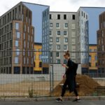 A woman walks past an office building near the Hauptbahnhof