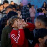 Displaced Palestinian children take part in an entertaining activity organised