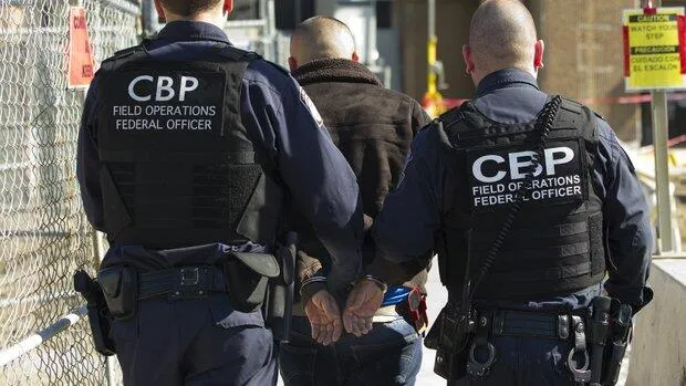 CBP officers escort a wanted person at a U.S. port of entry.